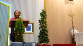 Rizal U Sinurat saat menyampaikan laporan perayaan Natal di Gereja Trinitas Paroki Cengkareng, Senin (25/12/2023) malam. (Foto: Tio)