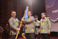 Menerima bendera Pataka Persatuan Wartawan Indonesia untuk dikibarkan dari ketua PWI DKI Jakarta Kesit B Handoyo