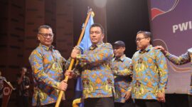 Menerima bendera Pataka Persatuan Wartawan Indonesia untuk dikibarkan dari ketua PWI DKI Jakarta Kesit B Handoyo