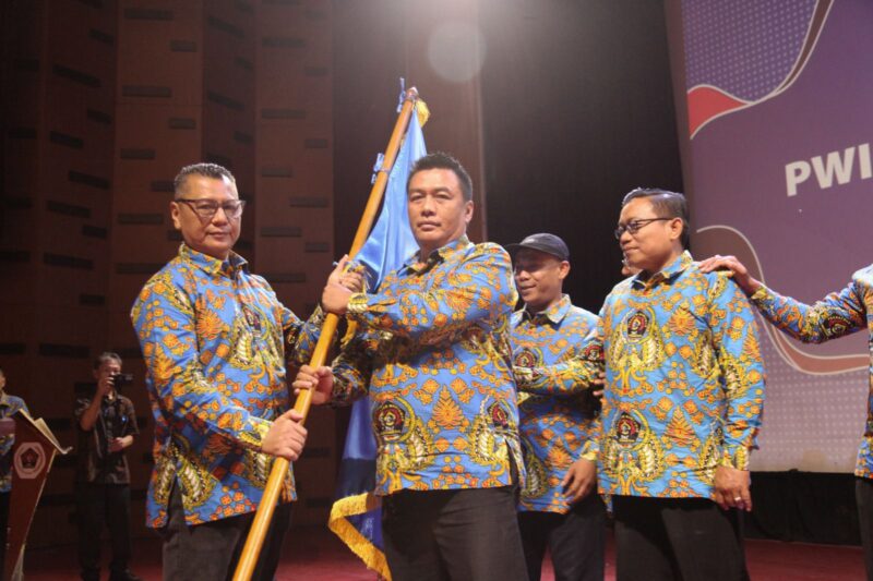 Menerima bendera Pataka Persatuan Wartawan Indonesia untuk dikibarkan dari ketua PWI DKI Jakarta Kesit B Handoyo