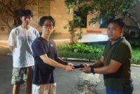 Briptu Novin Setya Wijaya menyerahkan  iPhone kepada nya.