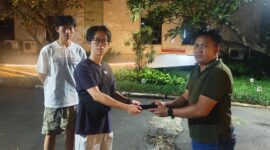 Briptu Novin Setya Wijaya menyerahkan  iPhone kepada nya.