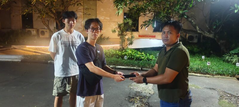 Briptu Novin Setya Wijaya menyerahkan  iPhone kepada nya.