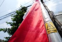 Umbul-umbul yang ditempel di tiang listrik bertanda ‘Awas Bahaya Listrik’ adalah contoh pemasangan yang salah dan berbahaya. Simbol peringatan sudah terpasang di tiang listrik agar siapapun tidak sembarang mendekati atau menyentuh. Mari jaga keselamatan bersama.