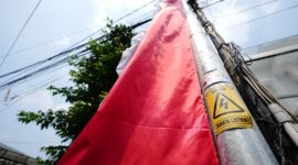 Umbul-umbul yang ditempel di tiang listrik bertanda ‘Awas Bahaya Listrik’ adalah contoh pemasangan yang salah dan berbahaya. Simbol peringatan sudah terpasang di tiang listrik agar siapapun tidak sembarang mendekati atau menyentuh. Mari jaga keselamatan bersama.