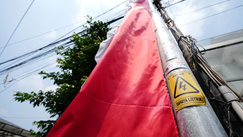Umbul-umbul yang ditempel di tiang listrik bertanda ‘Awas Bahaya Listrik’ adalah contoh pemasangan yang salah dan berbahaya. Simbol peringatan sudah terpasang di tiang listrik agar siapapun tidak sembarang mendekati atau menyentuh. Mari jaga keselamatan bersama.