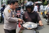 Kapolsek Kebon Jeruk Bagikan Bendera ke Warga, Semarakkan HUT RI ke-80 di Jalan Raya