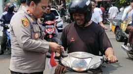 Kapolsek Kebon Jeruk Bagikan Bendera ke Warga, Semarakkan HUT RI ke-80 di Jalan Raya