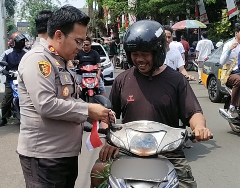 Kapolsek Kebon Jeruk Bagikan Bendera ke Warga, Semarakkan HUT RI ke-80 di Jalan Raya