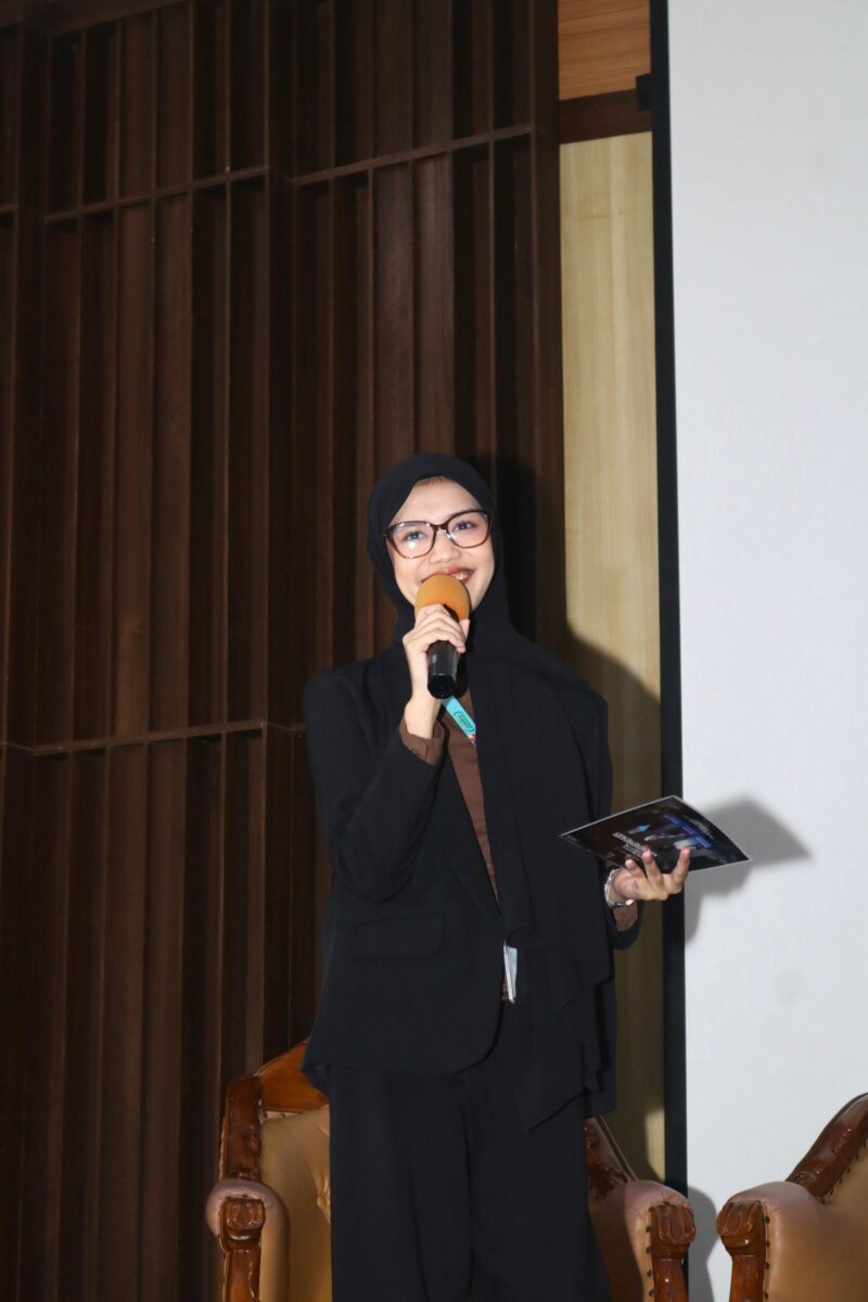 Foto: Asri Pratiwi Tenggara pembawa acara memandu jalannya kegiatan dengan penuh semangat di atas panggung. Dengan mengenakan busana formal, ia tampak percaya diri menyampaikan informasi kepada audiens yang hadir, menciptakan suasana acara yang hangat dan interaktif.
