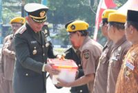 Foto: Danrem 081/DSJ Kolonel Arm Untoro Hariyanto menyerahkan bantuan sosial kepada veteran dan warakawuri usai upacara peringatan HUT ke-80 TNI di Alun-Alun Reksogati, Caruban, Kabupaten Madiun, Minggu (5/10/2025). 