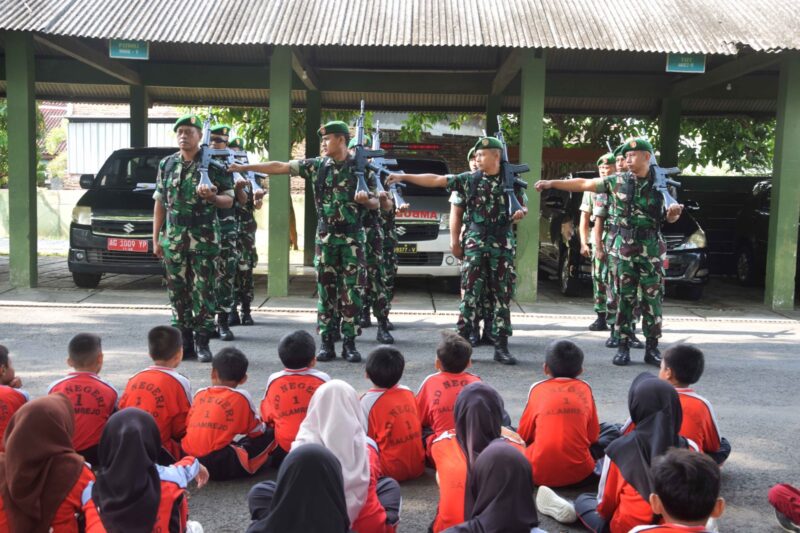 Foto: Prajurit Kodim 0806/Trenggalek memberikan materi peragaan Peraturan Baris Berbaris (PBB) kepada siswa SDN 1 Salamrejo dalam kegiatan outing class di Makodim, Jumat (10/10/2025).