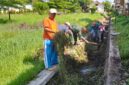 Foto: Babinsa Kelurahan Kampungdalem, Sertu Tugimin bersama warga bergotong royong membersihkan saluran air dari sampah dan rumput liar di Kecamatan Tulungagung, Sabtu (11/10/2025). 