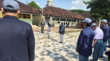Foto: Danposramil 0806/Suruh Peltu Eko Pujianto memimpin upacara bendera di SMKN 1 Suruh, Kecamatan Suruh, Kabupaten Trenggalek, Senin (20/10/2025).