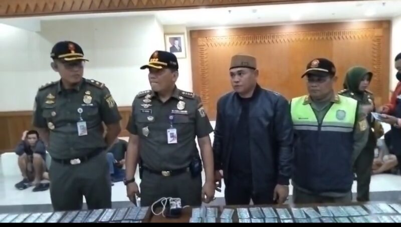 Foto: Kasatpol PP Jakarta Pusat Tumbur Parluhutan Purba (tengah) bersama jajarannya menunjukkan barang bukti hasil operasi penertiban di kawasan Tanah Abang, Jakarta Pusat, Senin (27/10/2025).