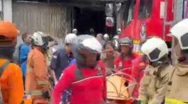 Foto: Petugas pemadam kebakaran mengevakuasi korban dari dalam gedung yang terbakar di kawasan Cempaka Baru, Kemayoran, Jakarta Pusat, Selasa (9/12/2025).