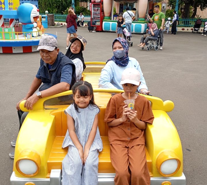 Foto: Bapak Sutobadi dan Ibu Ruliah, yang datang bersama anak-anak dari Eva Octaviani, Yupi, dan Rifda di Dufan, Ancol, Sabtu (27/12/2025). (Dok-Istimewa)