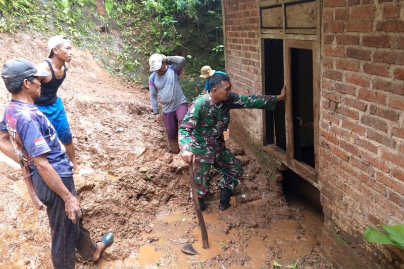 Foto: Babinsa bersama warga mengevakuasi material tanah longsor yang merusak rumah warga di Desa Siki, Kecamatan Dongko, Trenggalek, Jawa Timur