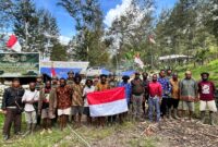 Foto: Sejumlah pemuda eks Organisasi Papua Merdeka (OPM) bersama prajurit TNI dan tokoh masyarakat berfoto sambil membentangkan bendera Merah Putih di Kampung Jampul, Distrik Beoga Barat, Kabupaten Puncak, Papua