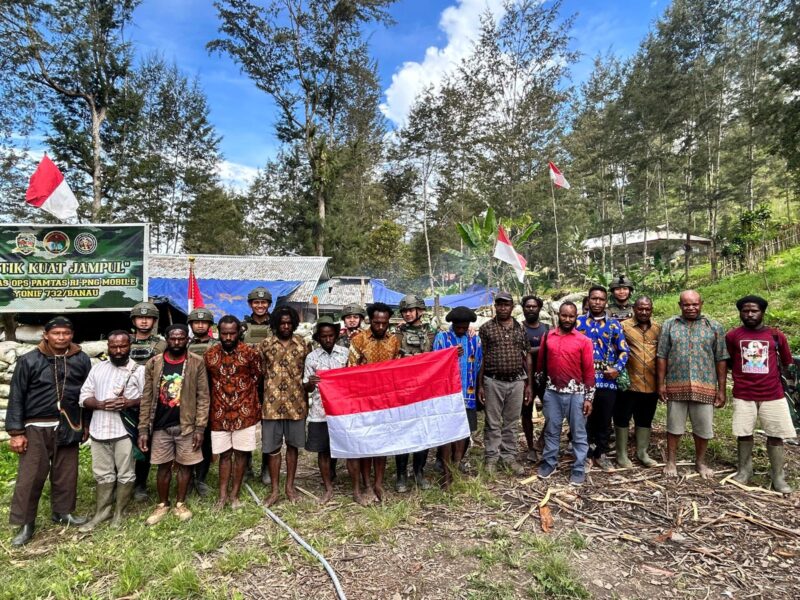 Foto: Sejumlah pemuda eks Organisasi Papua Merdeka (OPM) bersama prajurit TNI dan tokoh masyarakat berfoto sambil membentangkan bendera Merah Putih di Kampung Jampul, Distrik Beoga Barat, Kabupaten Puncak, Papua