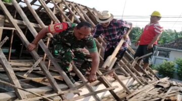 Foto: Seorang Babinsa bersama warga bergotong royong memperbaiki atap rumah milik Djumiati, warga Kelurahan Bendogrit, Kecamatan Sananwetan, Kota Blitar, Minggu (18/1/2026)
