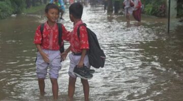 Foto: Murid sekolah dasar melintasi banjir yang merendam kawasan Taman Narogong, Rawalumbu, Bekasi, Jawa Barat, Kamis (22/1/2026). (Dok-Antara)