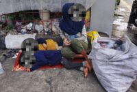 Foto: Laras seorang remaja perempuan bersandar lelah di sudut tembok pintu keluar SPBU Margonda, ditemani dua adiknya yang masih balita, terlelap di lantai keras beralas seadanya, Sabtu (24/1/2026). (Dok-Okj/FN)