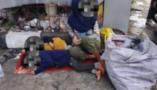 Foto: Laras seorang remaja perempuan bersandar lelah di sudut tembok pintu keluar SPBU Margonda, ditemani dua adiknya yang masih balita, terlelap di lantai keras beralas seadanya, Sabtu (24/1/2026). (Dok-Okj/FN)