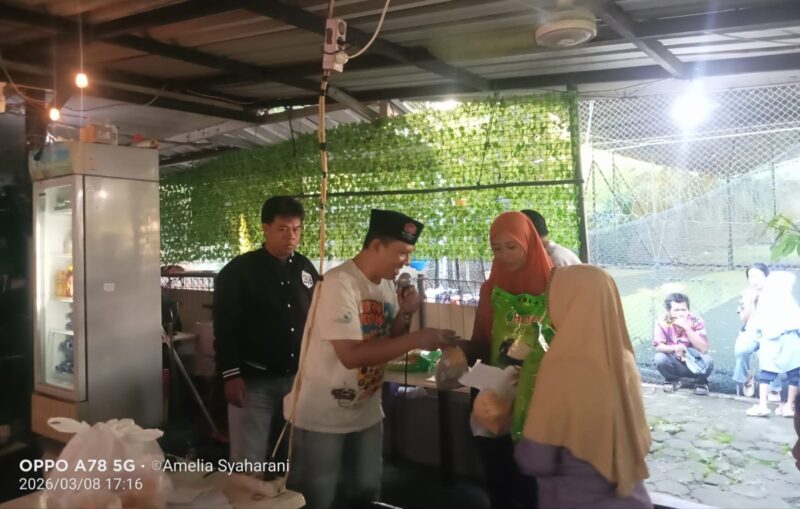 Foto: Seorang panitia dari Perpek Media menyerahkan santunan berupa beras dan paket sembako kepada penerima manfaat saat kegiatan santunan anak yatim/piatu dan janda dhuafa sekaligus buka puasa bersama di Kantin Laguna Sosial, Wijaya Kusuma, Jakarta Barat, Minggu (8/3/2026)