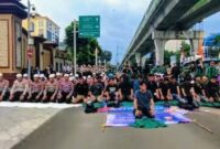 Foto: Anggota kepolisian yang sedang berjaga juga ikut menunaikan salat bersama para mahasiswa. (Dok-Istimewa)