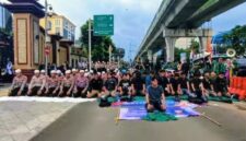 Foto: Anggota kepolisian yang sedang berjaga juga ikut menunaikan salat bersama para mahasiswa. (Dok-Istimewa)