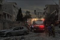 Foto : dengan tulisan Arab di bagian depan
Jalan dipenuhi puing-puing bangunan