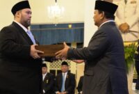 Foto: Prabowo Subianto menyerahkan dokumen pelantikan kepada Didi Mahardhika Sukarno dalam sebuah prosesi resmi di Istana Negara, Jakarta.