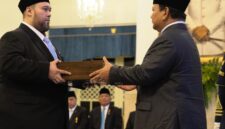 Foto: Prabowo Subianto menyerahkan dokumen pelantikan kepada Didi Mahardhika Sukarno dalam sebuah prosesi resmi di Istana Negara, Jakarta.