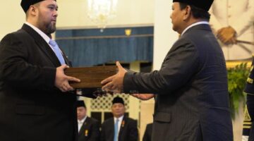 Foto: Prabowo Subianto menyerahkan dokumen pelantikan kepada Didi Mahardhika Sukarno dalam sebuah prosesi resmi di Istana Negara, Jakarta.