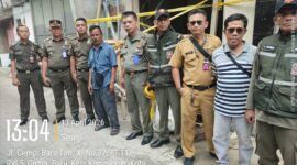 Foto: Petugas Satuan Polisi Pamong Praja (Satpol PP) Kecamatan Kemayoran bersama aparat terkait berdiri di lokasi proyek pembangunan Base Transceiver Station (BTS) yang disegel di Jalan Cempaka Baru Timur XI, Jakarta Pusat, Senin (13/4/2026)