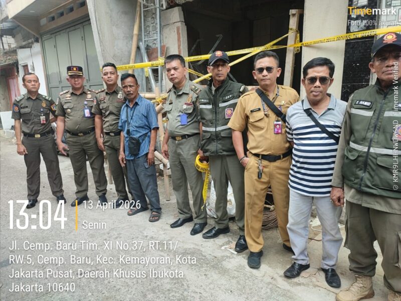 Foto: Petugas Satuan Polisi Pamong Praja (Satpol PP) Kecamatan Kemayoran bersama aparat terkait berdiri di lokasi proyek pembangunan Base Transceiver Station (BTS) yang disegel di Jalan Cempaka Baru Timur XI, Jakarta Pusat, Senin (13/4/2026)