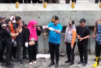 Foto: Wali Kota Jakarta Pusat, Arifin, menunjukkan ikan sapu-sapu hasil tangkapan saat memimpin kegiatan pengendalian spesies invasif di saluran air kawasan Plaza Indonesia.