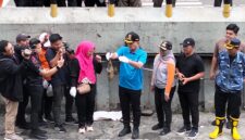 Foto: Wali Kota Jakarta Pusat, Arifin, menunjukkan ikan sapu-sapu hasil tangkapan saat memimpin kegiatan pengendalian spesies invasif di saluran air kawasan Plaza Indonesia.