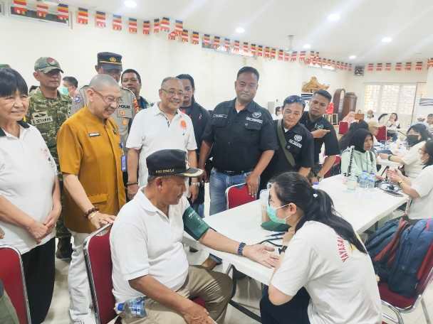 Foto: Seorang tenaga medis memeriksa tekanan darah warga dalam kegiatan bakti sosial kesehatan di Vihara Hemadhiro Mettavati, Kapuk, Cengkareng, Jakarta Barat, Minggu (26/4/2026). 