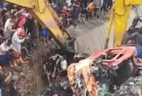 Foto: Alat berat dikerahkan untuk mengevakuasi kendaraan yang tertimbun longsor sampah di TPST Bantargebang, sementara puluhan warga memadati lokasi menyaksikan proses penyelamatan, Selasa (21/4/2026).