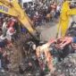 Foto: Alat berat dikerahkan untuk mengevakuasi kendaraan yang tertimbun longsor sampah di TPST Bantargebang, sementara puluhan warga memadati lokasi menyaksikan proses penyelamatan, Selasa (21/4/2026).
