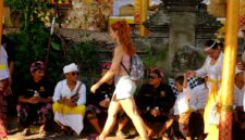 Wisatawan asing melewati masyarakat yang sedang istirahat saat upacara Odalan di Ubud, Bali. (Foto: hw)