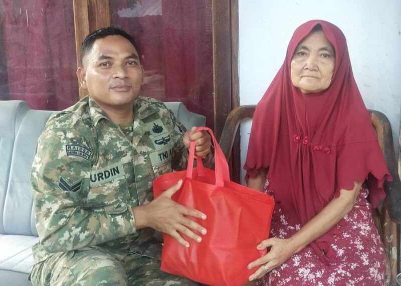 Foto: Sertu Nurdin menyerahkan bantuan sembako kepada seorang warga lanjut usia di Desa Dagangan, Kecamatan Dagangan, Kabupaten Madiun, Minggu (31/5/2026)