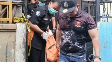Foto: Petugas kepolisian bersama tim identifikasi mengevakuasi jasad seorang ibu rumah tangga berinisial R (40) dari kediamannya di Jalan Padamulya VIII, Angke, Tambora.