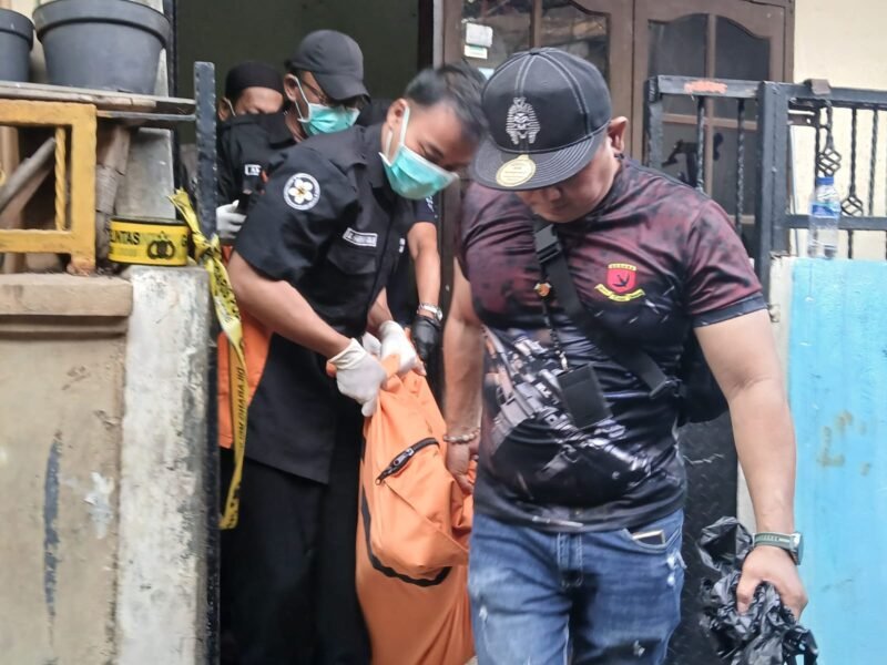 Foto: Petugas kepolisian bersama tim identifikasi mengevakuasi jasad seorang ibu rumah tangga berinisial R (40) dari kediamannya di Jalan Padamulya VIII, Angke, Tambora.