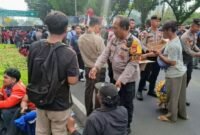 Foto: Personel Direktorat Samapta Polda Metro Jaya bersama jajaran Polsek Metro Gambir membagikan makanan ringan berupa roti dan air mineral kemasan kepada para peserta aksi, Senin (15/6/2026). (Dok-Istimewa)