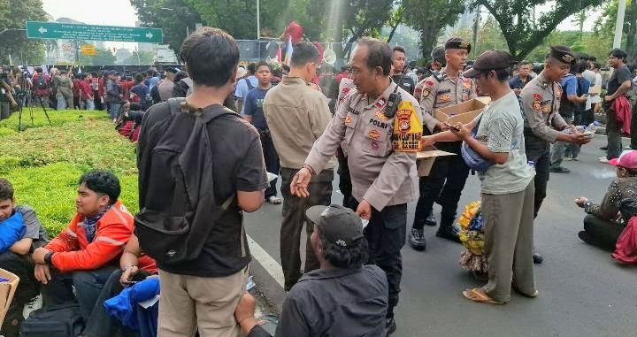 Foto: Personel Direktorat Samapta Polda Metro Jaya bersama jajaran Polsek Metro Gambir membagikan makanan ringan berupa roti dan air mineral kemasan kepada para peserta aksi, Senin (15/6/2026). (Dok-Istimewa)