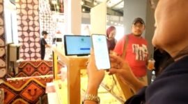Seorang pembeli di salah gerai di Stasiun LRT Dukuh Atas, membayar menggunakan QRIS melalui aplikasi di telepon genggamnya. (Foto: hw)