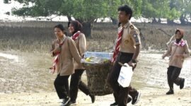 Foto: Anggota Saka Bahari bersama prajurit TNI Angkatan Laut membawa hasil pengumpulan sampah saat mengikuti aksi bersih pantai di kawasan Lapangan Tembak Cakra Kodaeral IV, Batam.
